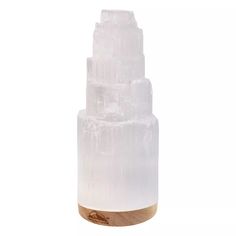 a tall white glass vase sitting on top of a table