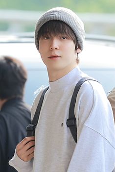 a young man wearing a gray hat and backpack