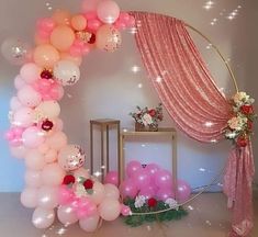 the balloon arch is decorated with pink and white balloons