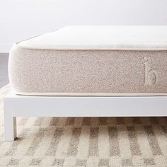 a white bed frame sitting on top of a carpeted floor