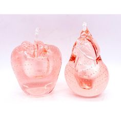 two pink glass apples sitting next to each other