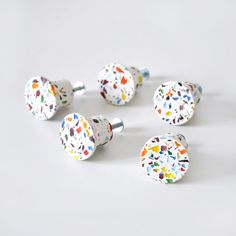 six colorful ceramic knobs with sprinkles on them