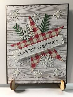 a handmade christmas card with snowflakes and pine cones on it, featuring the season's greetings stamp