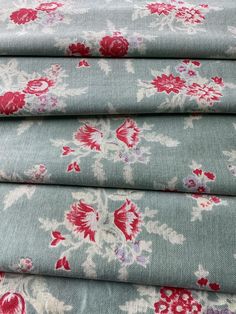 four pieces of blue fabric with red and white flowers on them, all in different sizes