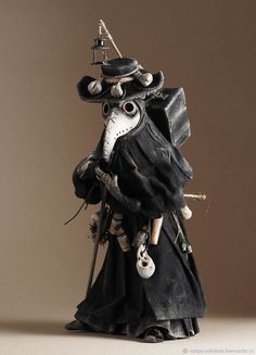 a figurine is dressed in black and has a hat on it's head