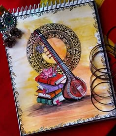 a drawing of a ukulele and some books on a red table with scissors