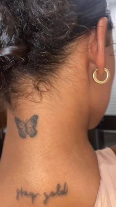 a woman with a butterfly tattoo on her neck