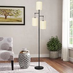 a living room with a white rug and two lamps on the floor next to a chair