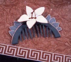 a blue and white comb with a flower on it