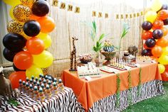 an animal themed birthday party with balloons and desserts