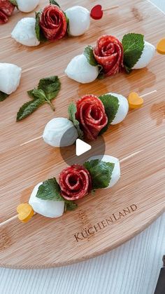 a wooden board topped with flowers and marshmallows