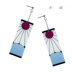 a pair of earrings with blue and white designs hanging from it's ear wires