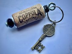 a cork keychain with a bottle opener attached to it that says agora