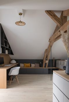 a room with white walls and wooden beams on the ceiling is furnished with modern furniture