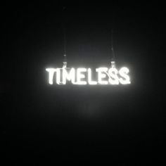 a neon sign that reads,'timeless'in white letters on a black background