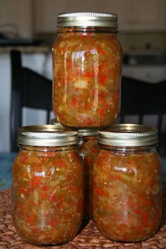 four jars filled with food sitting on top of a table