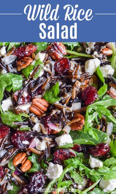 a salad with spinach, cranberries and feta cheese on the side