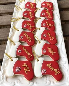 christmas cookies are arranged on a white platter with gold lettering and snowflakes