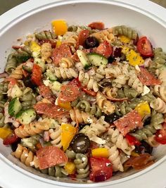 a white bowl filled with pasta salad on top of a table