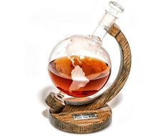 a glass filled with liquid sitting on top of a wooden stand in front of a white background