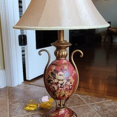 a lamp that is sitting on the floor in front of a door with a piano keyboard behind it