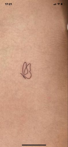 the back of a woman's stomach with a small heart tattoo on her left side