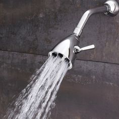 a faucet with water coming out of it's side spout, in front of a concrete wall