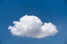 a large white cloud floating in the blue sky