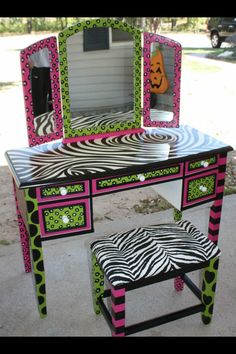 a zebra print dressing table with stool and mirror on the top, in front of a house