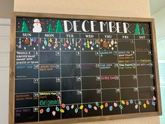 a chalkboard with a calendar on it that says december and is decorated with christmas lights