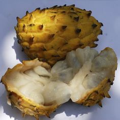 two pieces of fruit sitting on top of a white surface