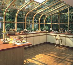 a large kitchen with lots of windows and wooden flooring, along with an island in the middle