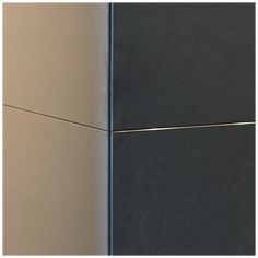 the corner of a black and tan wall with two wires attached to it's sides