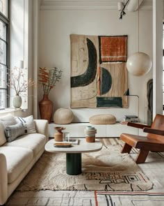 a living room filled with lots of furniture and art on the wall next to a window