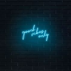 a neon sign that says good vibes only on a brick wall in the dark