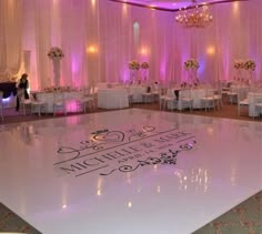 the dance floor is decorated with white chairs and chandeliers