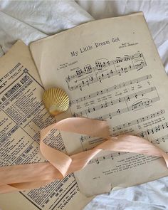 an old book with sheet music and a seashell