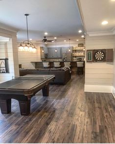 a living room filled with furniture and a pool table