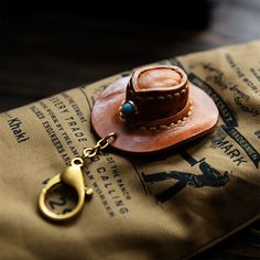 100% Handcrafted Mini Cowboy Hat! Unlock adventure and let your wild spirit roam free with this unique 100% handcrafted leather cowboy hat keychain! The natural vegetable tanned leather and its cowboy hat design give you a mini version of a classic western look. The solid brass clip help you clip it at anywhere you want. Make the great Outdoors yours! About the leather Specifications Made from veg tanned leather High quality solid brass trigger clip Size: 5.5 * 7.5 cm (W * H) 100% handcrafted Cowboy Hat Keychain, Chain Boots, Mini Cowboy Hat, Mini Cowboy, Hat Chain, Cowboy Hat Design, Leather Cowboy Hats, Boots Country, Western Accessories