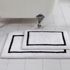 two bath mats sitting on top of a white tile floor