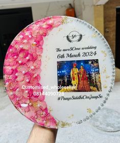 a person holding up a plate decorated with flowers and an advertisement for the wedding ceremony