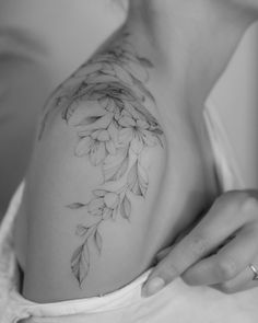 a black and white photo of a woman's breast with flowers on it,