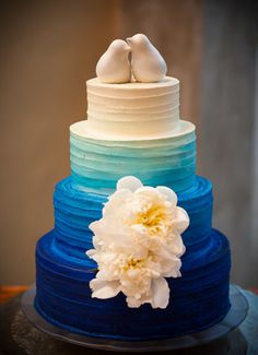 a wedding cake with blue layers and white flowers