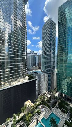 an aerial view of skyscrapers and pool in miami, with blue skies above them