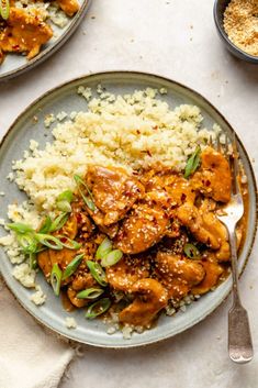 two plates filled with chicken and rice on top of a table