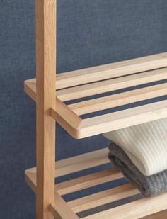 a wooden shelf with two folded towels on it