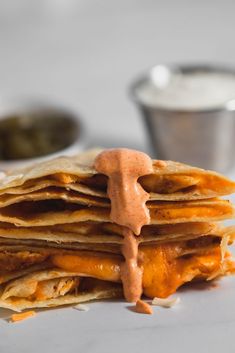 a stack of quesadillas with sauce drizzled on top