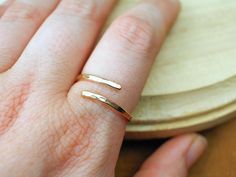 Our Hammered Wrap Ring features a beautiful textured design with elegance and simplicity. This ring is expertly crafted from high-quality 12k Yellow Gold Fill and showcases a hammered finish, giving it a distinct, artisanal look.  This Adjustable Yellow Gold Ring offers a perfect fit for any size, allowing you to comfortably adjust it to your finger. Its lightweight and comfortable design makes it easy to wear throughout the day,  For lovers of Minimalist Textured Jewelry, this Hammered Wrap Ring combines simplicity with artistic detail, making it a standout accessory.  Its understated yet sophisticated design allows you to wear it solo for a chic, modern vibe, or layer it with other rings for a bolder, stacked look. Whether you're treating yourself or searching for a thoughtful gift, this Handmade Minimalist Yellow Gold Midi Rings, Adjustable Hammered Yellow Gold Ring, Minimalist Adjustable Hammered Rings, Minimalist Hammered 14k Gold Stackable Rings, Minimalist 14k Gold-filled Midi Rings, Texture Jewelry, Gold Wrap Ring, Dainty Gold Rings, Gold Wrap