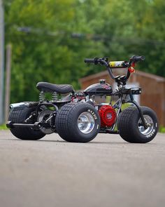 two wheeled scooters are parked on the pavement in front of some trees and buildings