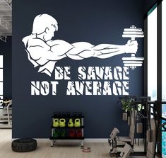 a gym room with a wall decal that says be savage not average